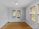 Empty bedroom with hardwood floors, neutral paint, ceiling fan, and large windows providing natural light at 2125 Kenilworth Ave, Charlotte, NC 28203