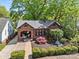 Charming brick home with manicured landscaping, flowering trees, and a covered front porch at 2125 Kenilworth Ave, Charlotte, NC 28203