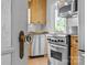 Partial view of a bright kitchen with stainless steel appliances and wooden cabinetry, seen through a vintage glass doorknob at 2125 Kenilworth Ave, Charlotte, NC 28203