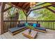 Open-air lounge on wooden deck features a modern couch, coffee table, and tree views at 2125 Kenilworth Ave, Charlotte, NC 28203