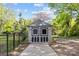 Storage shed in backyard has double doors, a concrete path, and is surrounded by a fence and greenery at 2125 Kenilworth Ave, Charlotte, NC 28203