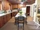 Traditional kitchen features wood cabinetry, checkerboard ceiling, and adjacent dining area at 215 Old Dixie Rd, Lancaster, SC 29720