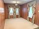 Empty living room with wood paneling and decorative curtains creating a cozy and vintage feel at 215 Old Dixie Rd, Lancaster, SC 29720