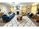 Bright living room featuring a fireplace, blue sofa and arm chair, and natural wood accents at 215 Old Dixie Rd, Lancaster, SC 29720