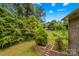 A tranquil backyard features lush greenery and a brick retaining wall with steps at 2281 Old Salisbury Concord Rd, Concord, NC 28025