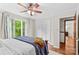 This bright bedroom features hardwood floors, a ceiling fan, and a large window offering backyard views at 2281 Old Salisbury Concord Rd, Concord, NC 28025