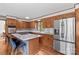 Well-lit kitchen features stainless steel fridge, custom wood cabinetry, and island with seating at 2281 Old Salisbury Concord Rd, Concord, NC 28025