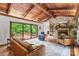 Bright living room features a stone fireplace, wood-beamed ceiling, hardwood floors, and deck access at 2281 Old Salisbury Concord Rd, Concord, NC 28025