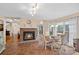 Cozy dining area features a brick fireplace, beautiful lighting, and large windows with sheer curtains at 276 Greyfriars Rd, Mooresville, NC 28117