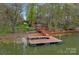 Stunning lakefront property featuring a private wooden dock and gazebo, offering serene water views and outdoor enjoyment at 276 Greyfriars Rd, Mooresville, NC 28117