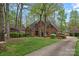 Stately red brick home with a long driveway, lush lawn, and mature trees creating a private setting at 276 Greyfriars Rd, Mooresville, NC 28117