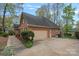 Spacious three-car garage with an attached driveway and meticulously maintained landscaping at 276 Greyfriars Rd, Mooresville, NC 28117