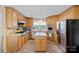 Charming kitchen with stainless steel appliances, kitchen island, tile flooring, and wooden cabinets at 276 Greyfriars Rd, Mooresville, NC 28117