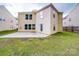 Backyard view featuring a large patio, lush green lawn, and a sunny, two-story home at 3227 Deshler Morris Ln, Charlotte, NC 28216