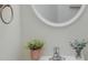 Bright powder room features an oval mirror, brushed nickel faucet, and a faux plant to add warmth at 3227 Deshler Morris Ln, Charlotte, NC 28216