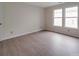 Well-lit bedroom featuring modern flooring, neutral walls, and natural light from two windows at 3227 Deshler Morris Ln, Charlotte, NC 28216