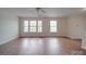 Spacious living room featuring hardwood floors, a ceiling fan and multiple windows at 3227 Deshler Morris Ln, Charlotte, NC 28216