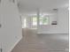 Open-concept living room with new gray floors, white walls, and multiple windows for natural light at 3227 Deshler Morris Ln, Charlotte, NC 28216
