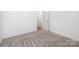 This bedroom features neutral carpet, white walls, and a doorway to additional rooms at 327 Lincoln Sw St, Concord, NC 28025