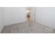 The bedroom is freshly carpeted and has an open doorway that leads to the kitchen at 327 Lincoln Sw St, Concord, NC 28025