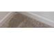 Close-up view of neutral-toned carpet flooring with white baseboards at 327 Lincoln Sw St, Concord, NC 28025