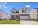 Charming two-story home featuring a covered porch, two-car garage, and well-maintained lawn on a sunny day at 3286 Shining Rock Sw St, Concord, NC 28027