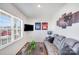 Cozy living room featuring a plush gray sofa, mounted TV, sports memorabilia and natural light from a window at 3286 Shining Rock Sw St, Concord, NC 28027