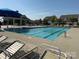 Community pool with blue umbrellas, lots of lounge chairs, and nearby clubhouse for residents enjoyment at 3286 Shining Rock Sw St, Concord, NC 28027