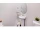 A well-lit powder room featuring a pedestal sink, oval mirror, and modern fixtures at 3286 Shining Rock Sw St, Concord, NC 28027