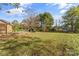 Backyard view of the lawn with mature trees and a small deck in the background at 3320 28Th Ne St, Hickory, NC 28601