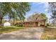 View of this quaint home featuring a covered carport and cozy front porch, and mature trees overhead at 3320 28Th Ne St, Hickory, NC 28601