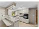 This quaint kitchen features a breakfast bar, white cabinets and appliances, and bright, natural light at 3320 28Th Ne St, Hickory, NC 28601