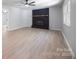 Open living room with a brick fireplace, modern ceiling fan and light-colored floors at 3715 Dallas High Shoals Hwy, Dallas, NC 28034