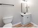 Updated bathroom with a new vanity, mirror, and toilet, complemented by modern fixtures and wood-look flooring at 4303 Greenhaven Ln, Gastonia, NC 28056