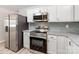 Modern kitchen featuring stainless appliances, granite countertops with mosaic backsplash, and white cabinets at 4303 Greenhaven Ln, Gastonia, NC 28056