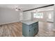 Open-concept kitchen with granite island, new laminate flooring, beam accent, and neutral paint at 4303 Greenhaven Ln, Gastonia, NC 28056