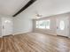 Bright living room with new laminate flooring, beam accent, neutral paint, and updated ceiling fan at 4303 Greenhaven Ln, Gastonia, NC 28056
