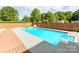 Sparkling pool with spacious patio, wooden deck, and privacy fence, perfect for summer enjoyment at 4303 Greenhaven Ln, Gastonia, NC 28056