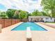 Inviting in-ground pool with diving board, surrounded by concrete patio and greenery at 4303 Greenhaven Ln, Gastonia, NC 28056
