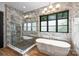 Bathroom featuring a soaking tub with a luxurious marble surround and glass enclosed shower at 438 Wonderwood Dr, Charlotte, NC 28211