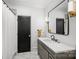 Modern bathroom with sleek vanity, elegant mirror, and a shower featuring a black framed door at 438 Wonderwood Dr, Charlotte, NC 28211