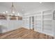 Open dining area featuring hardwood floors, wainscoting, a chandelier, and custom built-ins at 438 Wonderwood Dr, Charlotte, NC 28211