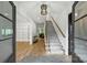 Bright foyer featuring hardwood floors, staircase, modern lighting, and access to living spaces at 438 Wonderwood Dr, Charlotte, NC 28211