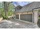 Attached two-car garage with painted doors and concrete driveway leading to the house at 438 Wonderwood Dr, Charlotte, NC 28211
