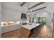 Elegant kitchen with white cabinets, stainless steel appliances, a large island and wood accents at 438 Wonderwood Dr, Charlotte, NC 28211