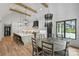 Bright, open kitchen with a large island, modern lighting, and a dining area with rustic wood table at 438 Wonderwood Dr, Charlotte, NC 28211