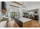 Open kitchen and dining area with an island, stainless steel appliances, and view into the living room at 438 Wonderwood Dr, Charlotte, NC 28211