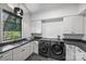 Functional laundry room with modern washer/dryer units and ample counter space at 438 Wonderwood Dr, Charlotte, NC 28211