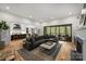 Open-concept living room with a large sectional sofa, fireplace, and sliding doors to the deck at 438 Wonderwood Dr, Charlotte, NC 28211
