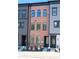Three-story townhome featuring a brick exterior, arched windows, dark trim, and landscaped front yard at 451 Old Town Village Rd, Waxhaw, NC 28173